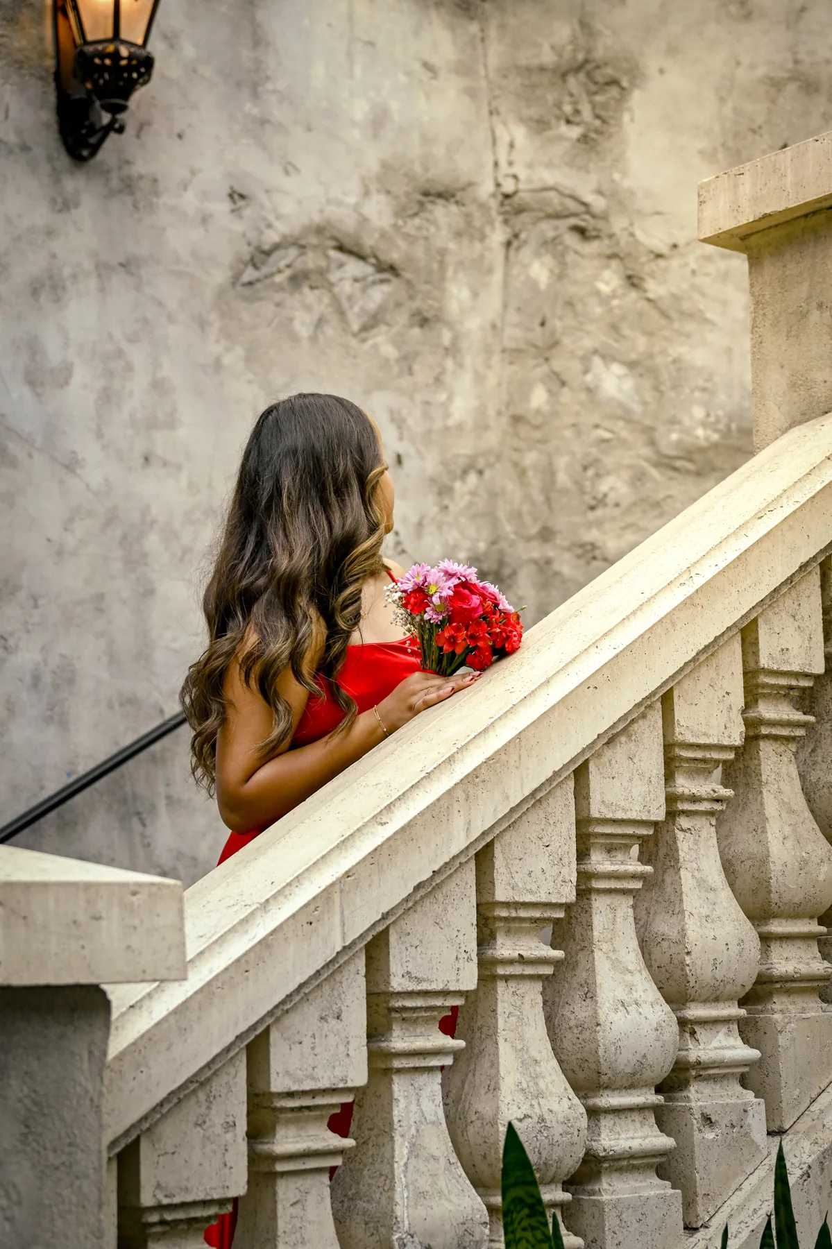 A person in a red dress on a stone staircase