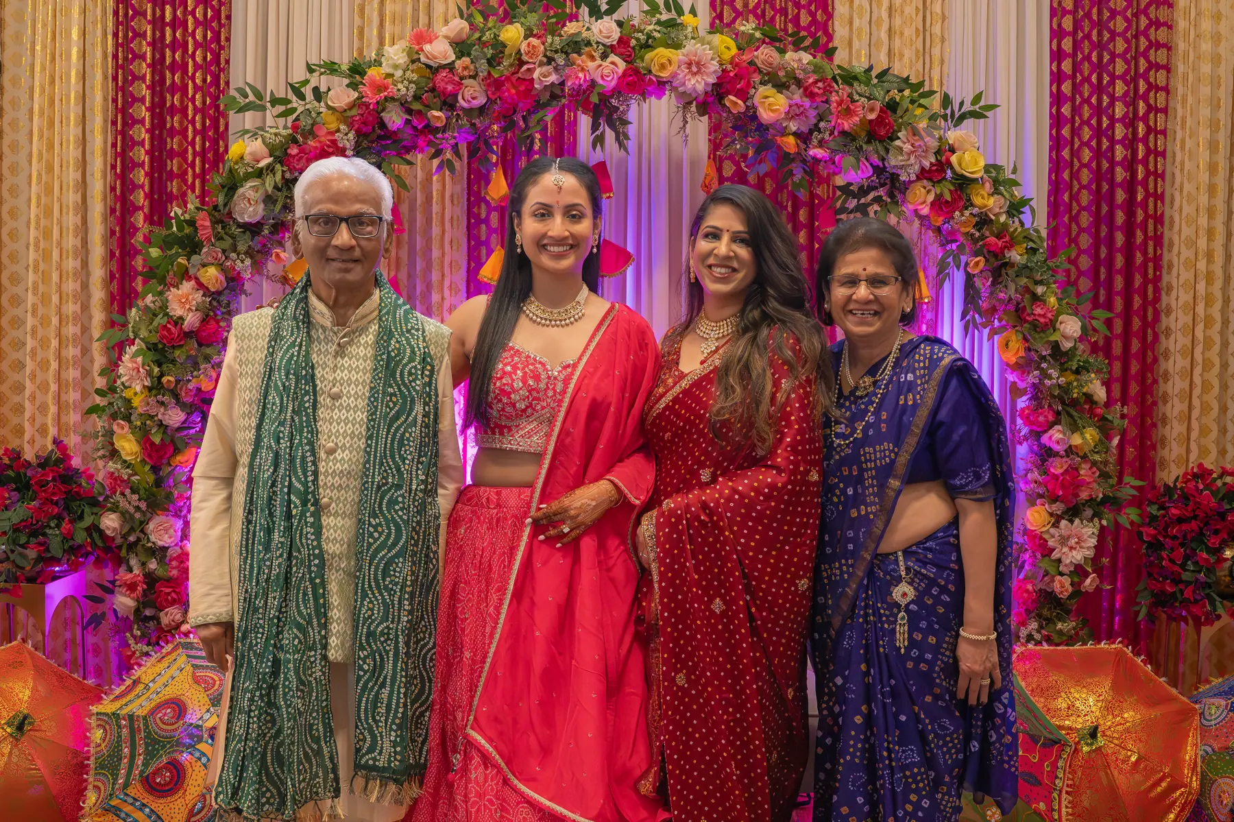 A group posing together beside a floral celebration backdrop