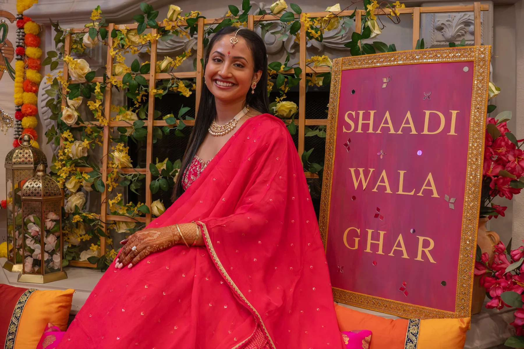 Portrait in pink beside a colorful flower-covered backdrop