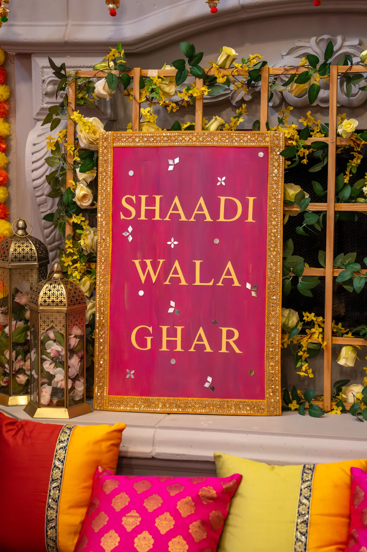 A bright celebration sign among flowers and draped fabric