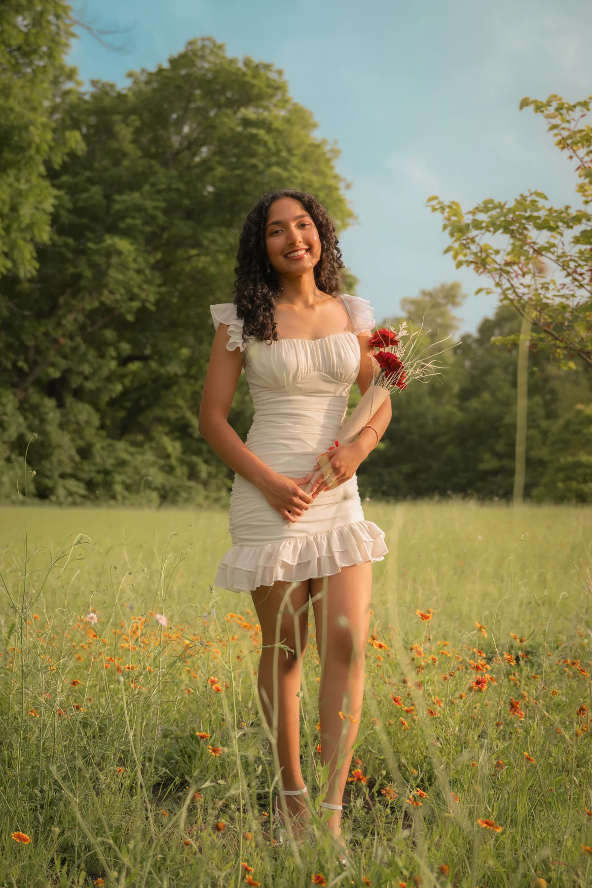 Portrait holding flowers on a sunlit woodland path