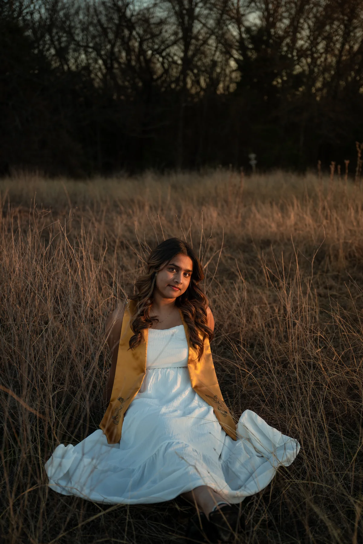 Portrait seated in a white dress in an evening field
