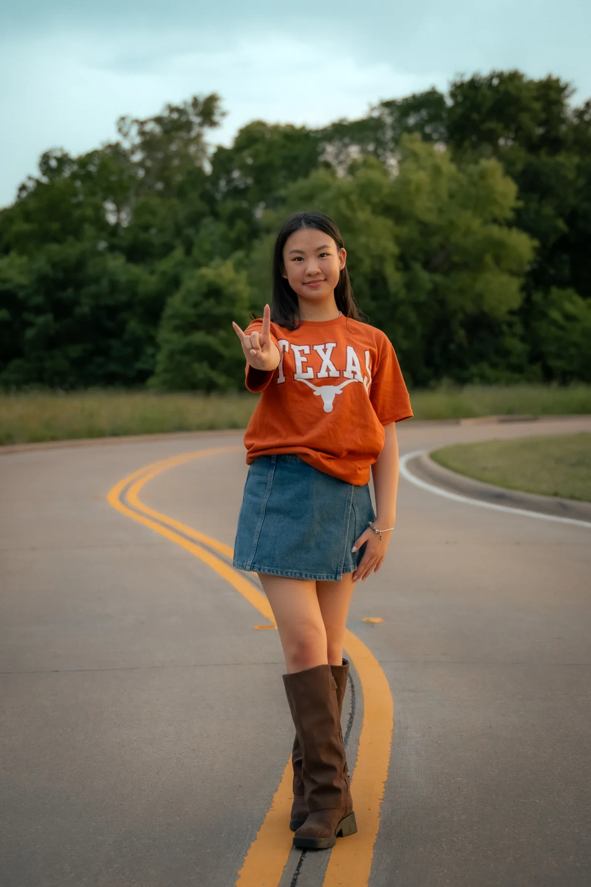 Portrait in an orange shirt standing on the center line of a road