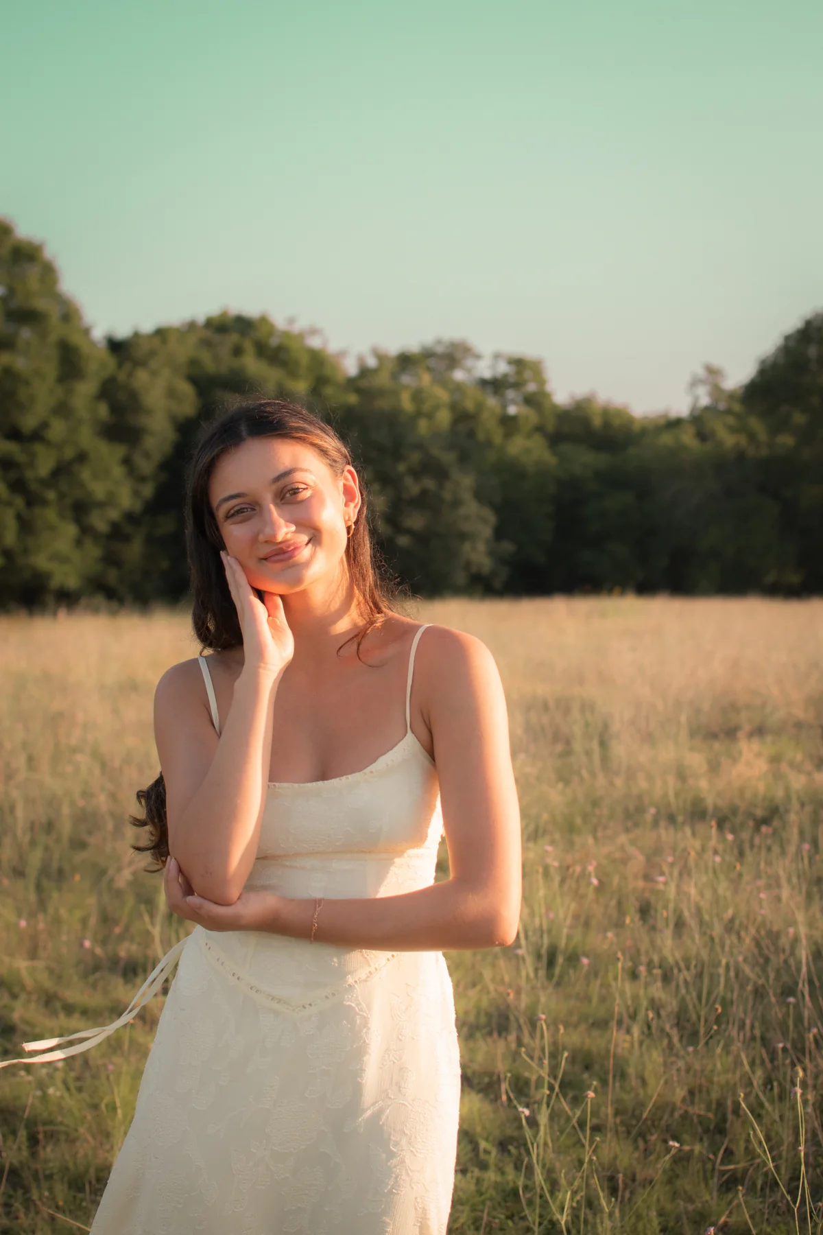 Portrait in a white dress beside a golden field