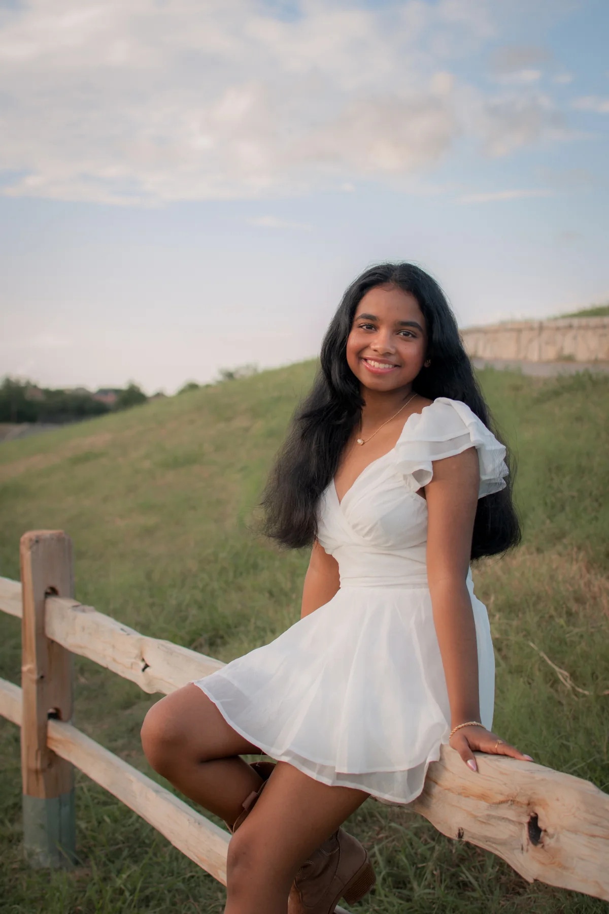 Portrait in a white dress beside a beach boardwalk