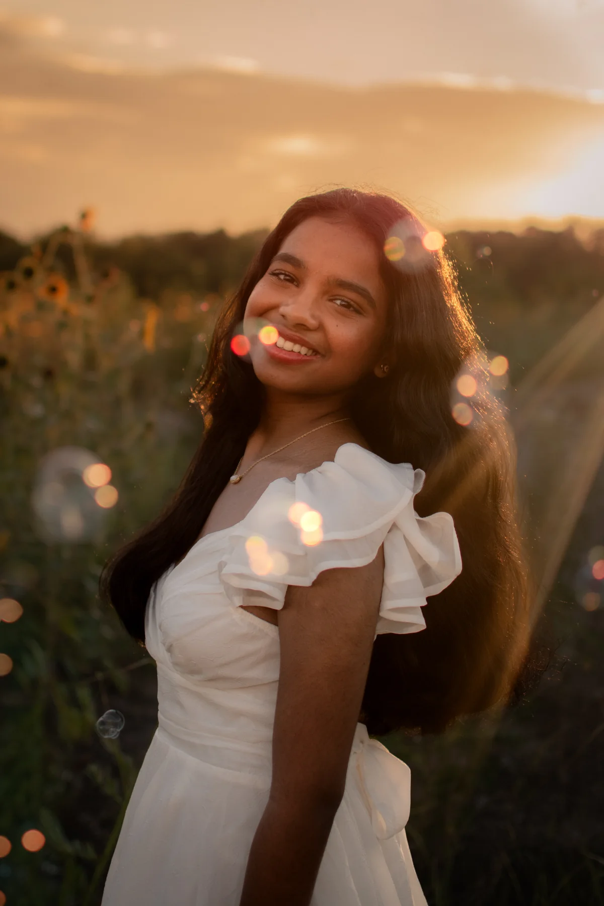 Portrait looking back in a flowered white dress at sunset