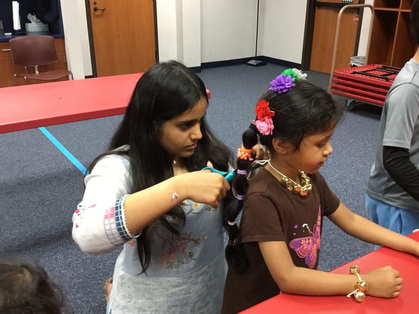Saanavi helps a young workshop participant try on Bharatanatyam hair ornaments